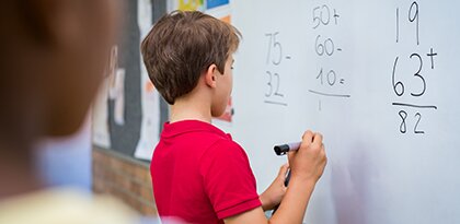 boy doing math on whiteboard